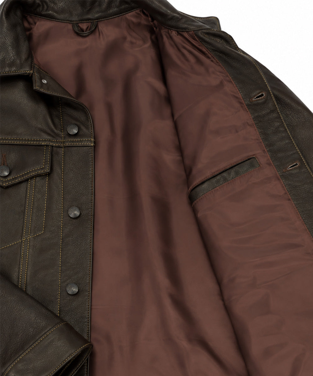 Close-up of a brown leather jacket showing the dark brown interior lining, buttoned front flap pocket, and dark brown outer fabric with contrast stitching.