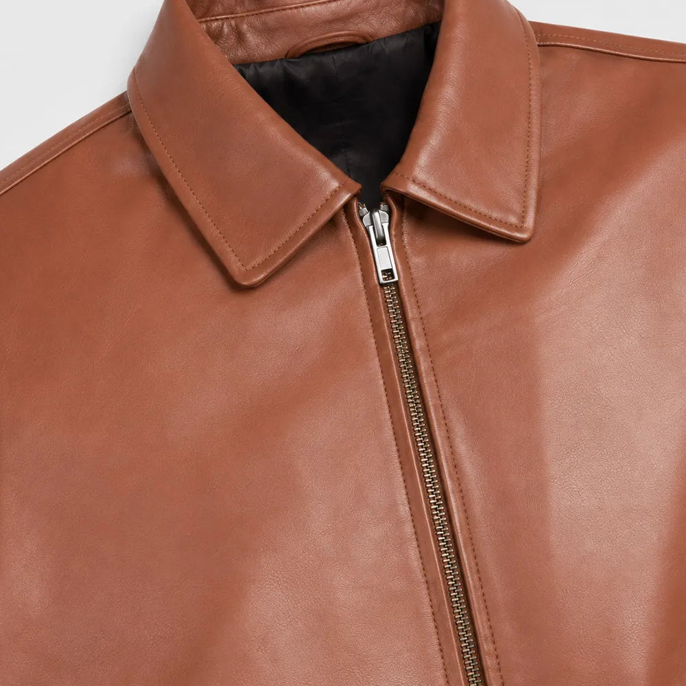 Close-up of the shirt collar, smooth zipper, and genuine lambskin leather on a men's Harrington leather jacket.