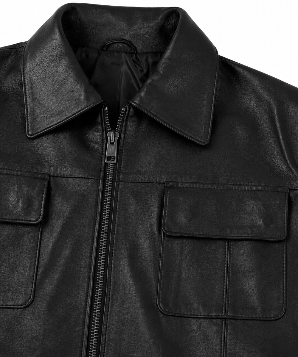 Close-up of a black leather jacket with a collar, front zipper, and two flap chest pockets on a white background.