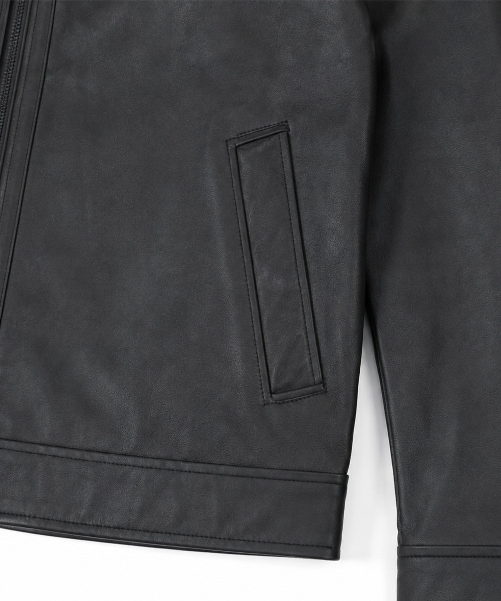 Close-up of a black faux-leather jacket showing a vertical welt pocket and zipper detail against a white background.