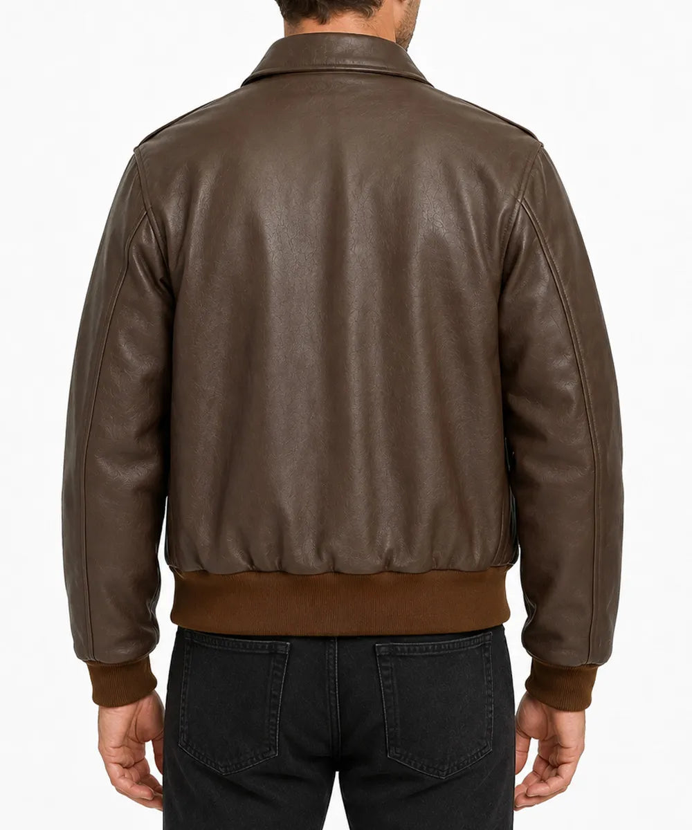 A man viewed from the back wearing a dark brown leather jacket with ribbed knit trim at the hem and cuffs, paired with black jeans, against a plain white background.