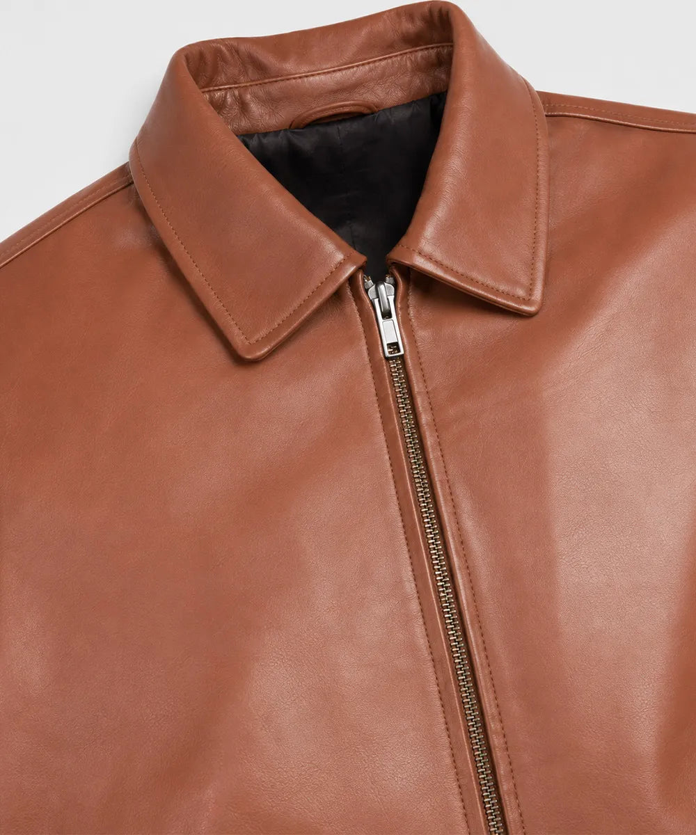 Close-up of the shirt collar, smooth zipper, and genuine lambskin leather on a men's Harrington leather jacket.