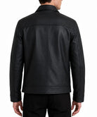 A man viewed from the back wearing a black leather jacket and black pants against a plain white background.