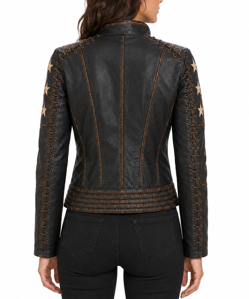 A woman viewed from the back wearing a black leather jacket with decorative gold-toned stitching, lace-up details, and star motifs on the sleeves, paired with black jeans against a plain white background.